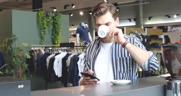 Young Adult Using Smartphone and Drink Coffee in Fashion Store