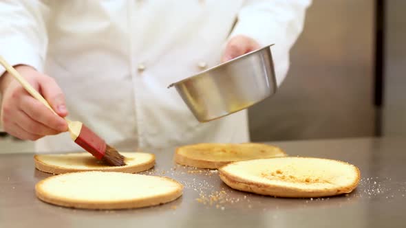 Pastry chef at work in a or cake shop preparing a sweet cake
