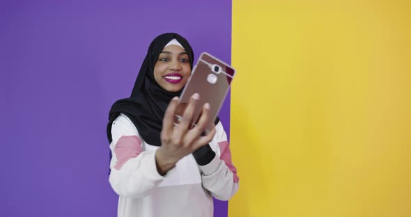 Portrait of Smiling African Black Muslim Girl Posing at Color Studio Background Taking Selfie Photo alt