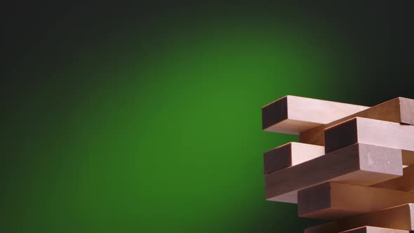 A Tower Made of Wooden Blocks on a Green Gradient Background alt