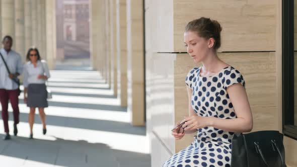 Upset Young Business Lady Sitting Outside Office Building Being Fired alt