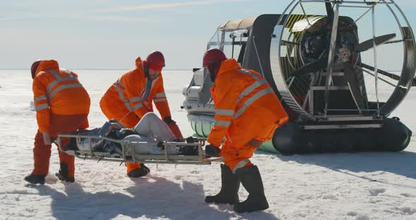 Lifesavers Reanimating Victim on Stretchers in Arctic on Frozen Ocean alt