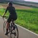 Road cycling. Female cyclist with fit and muscular body riding on bicycle at sunset - VideoHive Item for Sale
