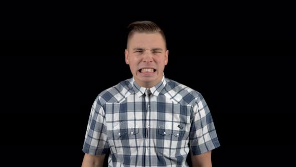 A Young Man Takes Off His Mask and Shows Emotion on His Face. Angry Man in a Shirt. A Man Hides His alt