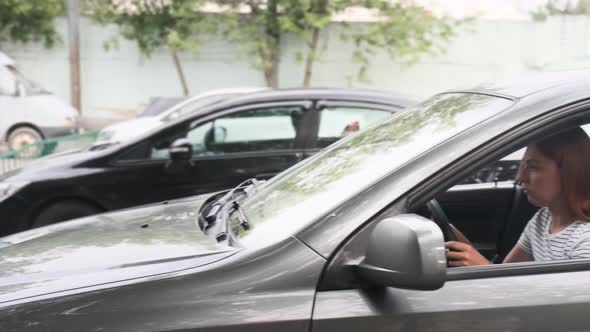 Young Woman Crashed While Parking a car.Car Accident on the Road alt