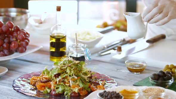 Spoon Pouring Liquid on Salad. alt