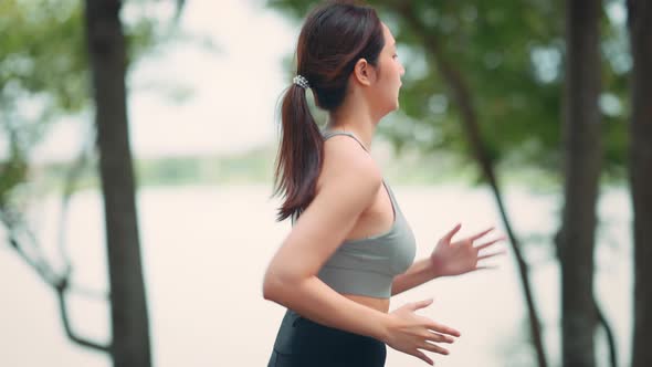 Runner young woman running in the summer park alt