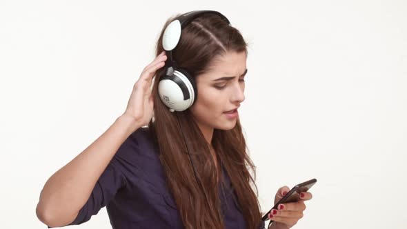 Active Young Caucasian Female with Long Brown Hair Wearing Dark Blue Shirt Listening Music From alt