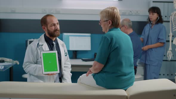 Male Physician Vertically Holding Digital Tablet with Green Screen alt