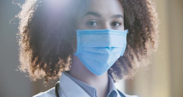 Portrait of Young African American Female Surgeon Doctor Nurse Taking Off Her Mask After Successful alt