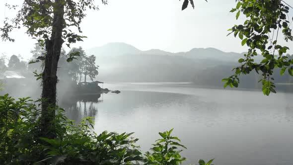 Cinematic aerial view reveal shot of a misty lake in the morning