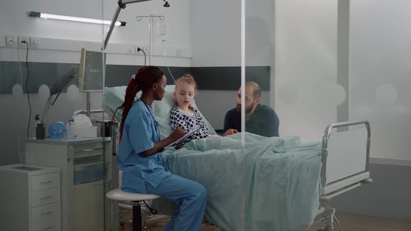 African American Practitioner Asisstant Writing Sickness Symptoms on Clipboard alt