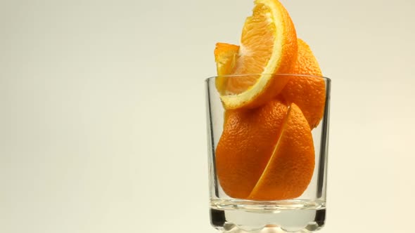Pieces Of Orange Lie In A Glass For A Cocktail And The Glass Rotates