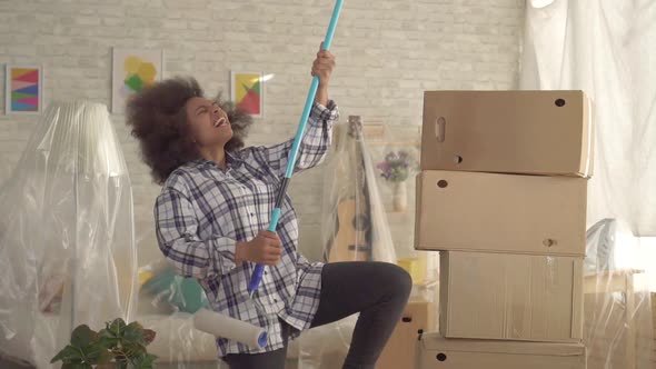 Happy African American Woman Dancing with Paint Roller Like Guitar Player Slow Mo alt