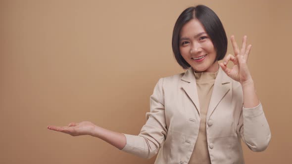 Asian business woman happy smiling show her hands in OK sign language with copy space isolated