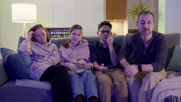 A Family of Four  Father Mother Son and Daughter Watch TV in the Evening alt