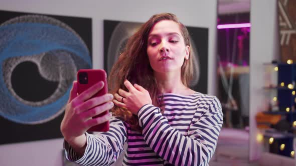 A Young Woman is Making a Selfie alt