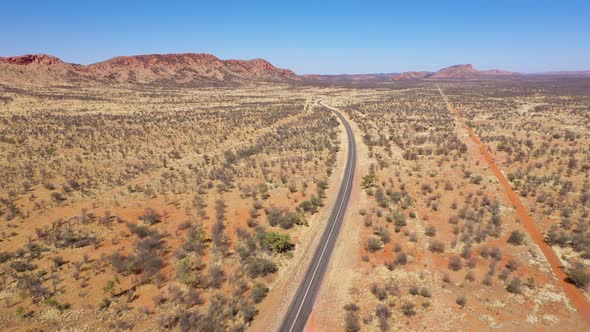 Australia outback desert road aerial near West MacDonnell National Park, Alice Springs, Northern Ter alt