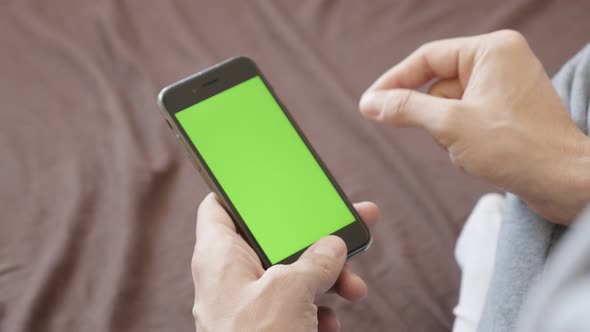 ZAJECAR, SERBIA - JANUARY 2017 Finger gestures over  black greenscreen smart phone in man hand close alt