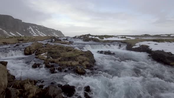 Winter landscape in Iceland with river and waterfall through the countryside