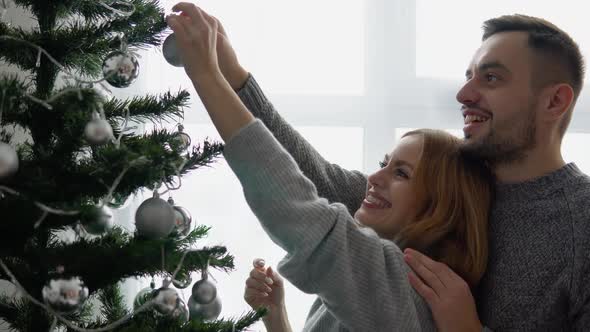 Couple Decorating the Christmas Tree Together in the Christmas Eve alt