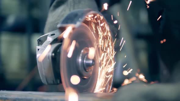 Angle Grinder Cutting Metal at a Factory. Lots of Grinding Sparks. alt