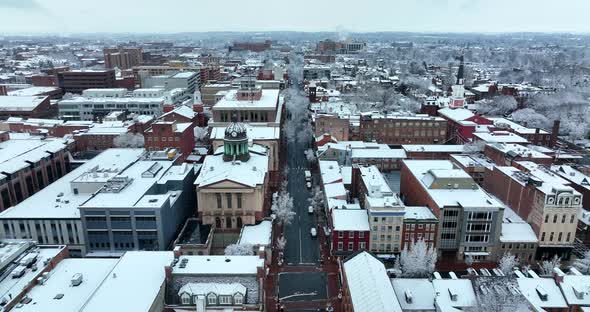 Lancaster PA aerial reveal shot during winter snow. Courthouse church steeples downtown commercial b alt