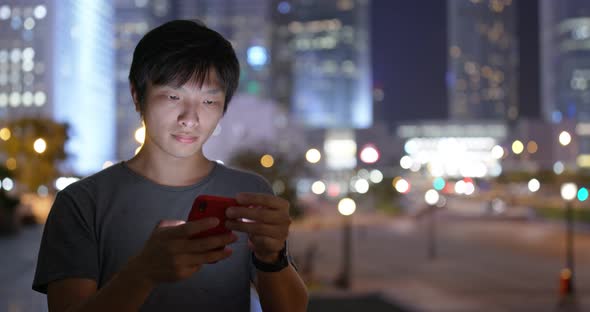 Asian man use of mobile phone in city at night alt