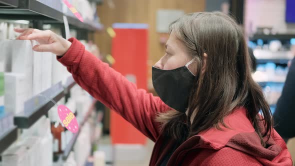 Girl in a Medical Mask Buys New Cosmetics in a Store