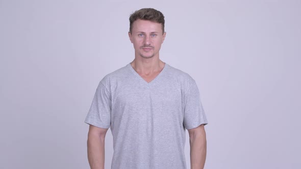 Happy Handsome Bearded Man Smiling with Arms Crossed alt