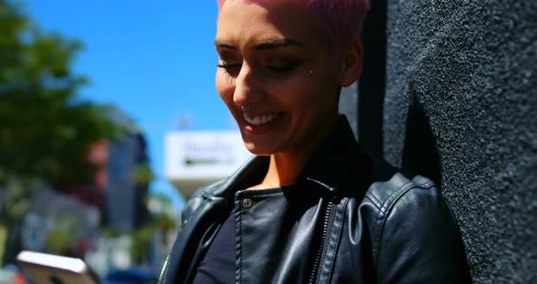 Pink hair woman using mobile phone in alley 4k alt