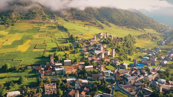Aerial drone view of a village in Georgia. Valley, buildings, mountains and hills slopes covered wit alt