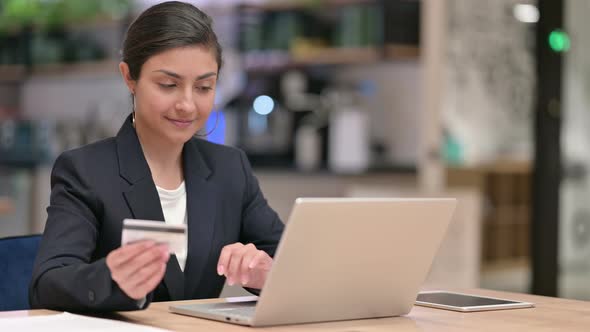 Indian Businesswoman Making Successful Online Payment on Laptop in Office  alt