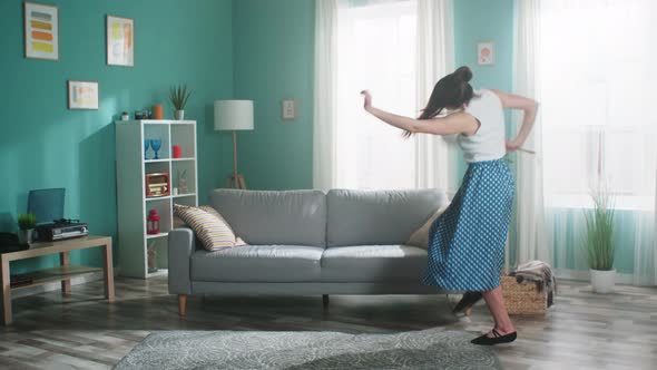 Energetic Woman Is Dancing and Cleaning Living Room