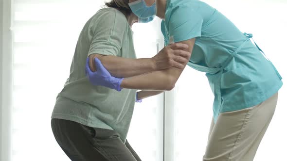 Doctor or Nurse is Helping an Elderly Woman to Get to Her Feet alt