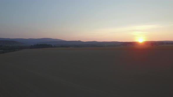 Aerial View On The Field And Sunset. Mountains In The Background 