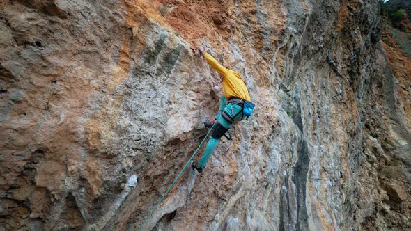 Aerial Slow Motion Back View Strong Man Rock Climber Climbs on Overhanging Limestone Cliff with alt