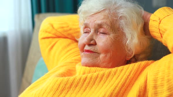 Mature Woman Dreaming Thinking About Good Future Sitting on Sofa in Living Room alt
