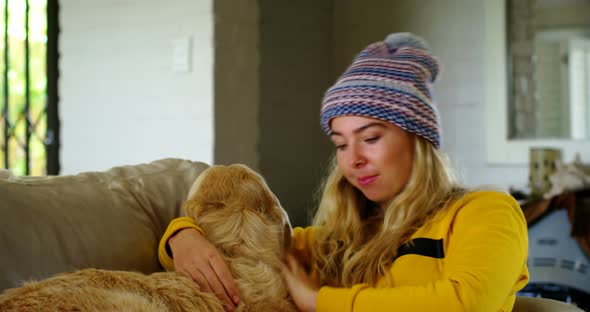 Woman reading book with her dog on sofa 4k alt