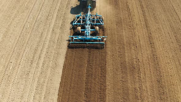 Tractor with Disc Harrows on the Farmland alt