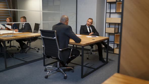 Two Diverse Businessmen Discussing Planning Talking During Evening Briefing at Modern Boardroom alt
