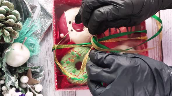 unpacking a christmas donut box, donuts with icing and sprinkles