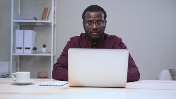Businessman Working with Laptop and Posing for Camera at Table in Modern Office Spbas alt