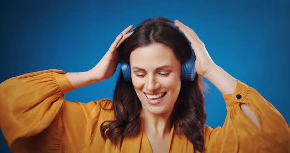 Happy Young Woman Listen Music in Headphones at Studio