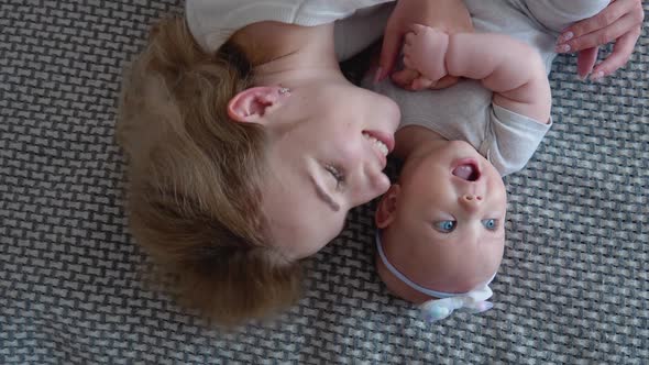 Mother and Baby Girl Lying on the Bed Face Up alt
