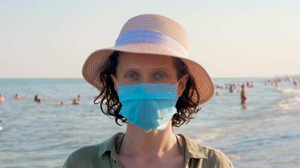 Woman in disposable mask looking at the camera. Vacation and coronavirus outbreak.
