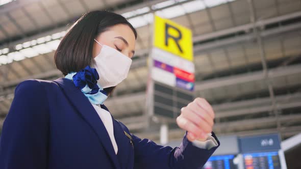 Airliner air hostess crew wearing face mask walking in airport terminal to the airplane during Covid alt