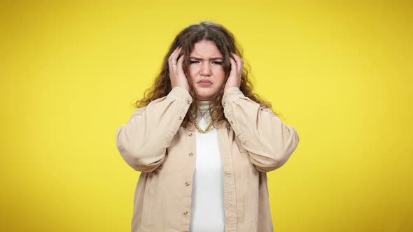 Fatigued Plussize Woman Holding Head in Hands Looking at Camera with Sad Facial Expression alt