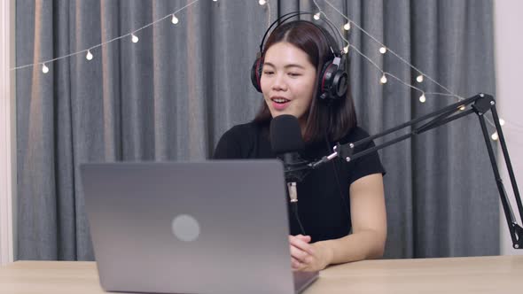 Asian female influencer recording a vlog using podcast microphone for vlogging and recording podcast