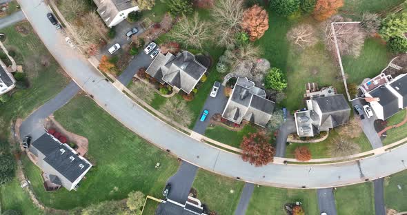 Top down aerial of neighborhood. Curvy road through community. Autumn scene. alt